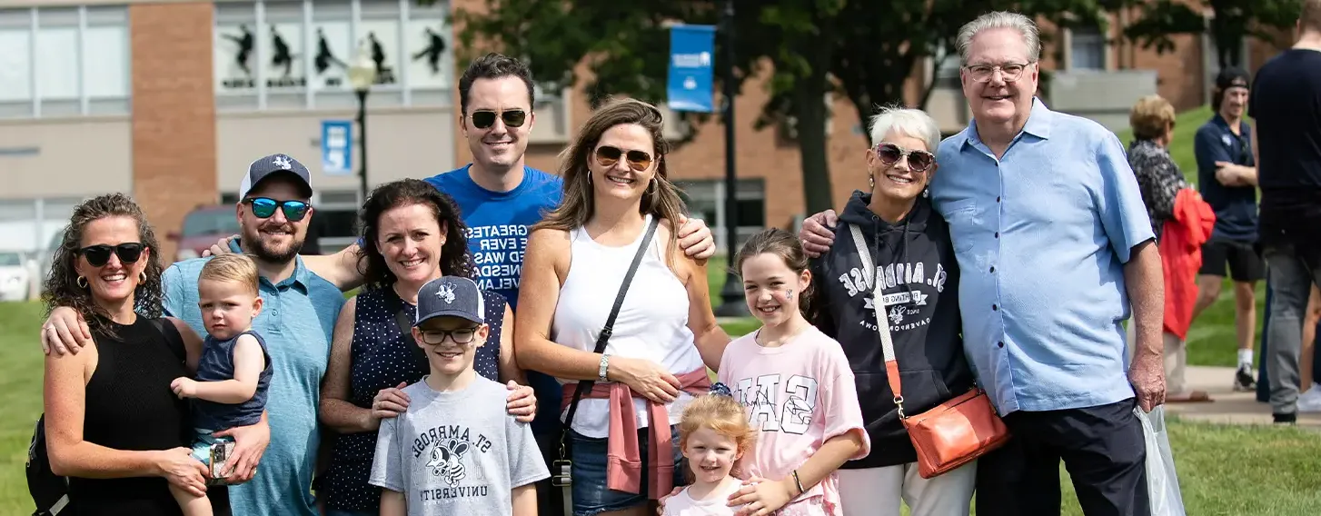 A happy family standing in front of a building, smiling.